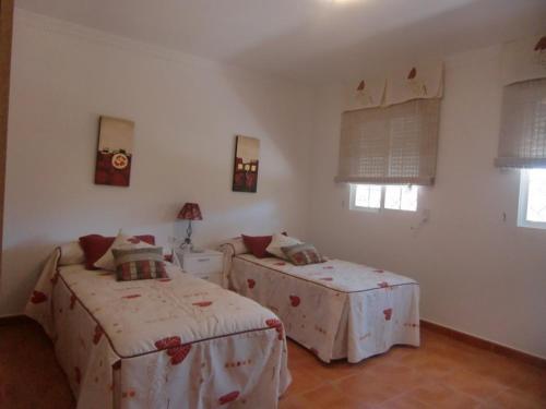 カラバルディナにあるVilla Biznaga Playa Piscinaのベッドルーム1室(ベッド2台付)