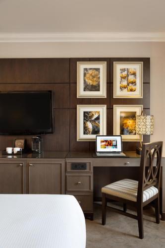 a bedroom with a desk with a television and a chair at Fairmont Château Lake Louise in Lake Louise