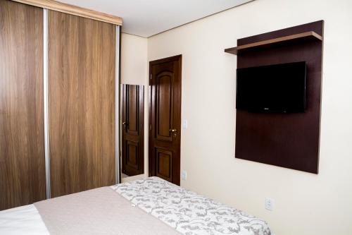 a bedroom with a bed and a flat screen tv at Executivo Flat II in Parauapebas