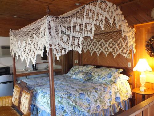 a bedroom with a canopy bed with a wooden ceiling at Scarborough Inn in Manteo