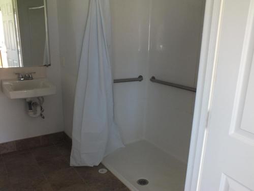a bathroom with a shower and a sink at Scarborough Inn in Manteo