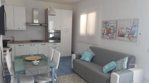 uma cozinha e uma sala de estar com um sofá e uma mesa em Residence Amalia em Pantelleria