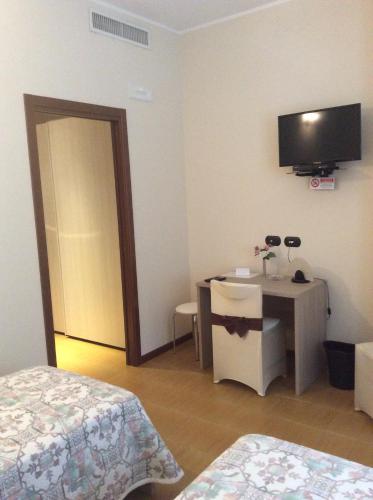 a room with a bedroom with a desk and a television at B&B Notte sul Lago in Gozzano