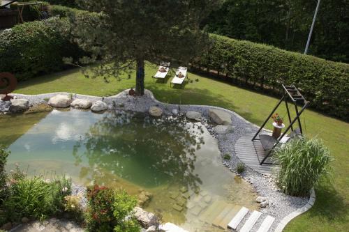 a person sitting on a swing next to a pond at Das Landhaus in Pfronten
