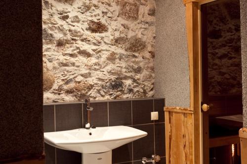 a bathroom with a sink and a stone wall at Nuustaku Rancho in Otepää