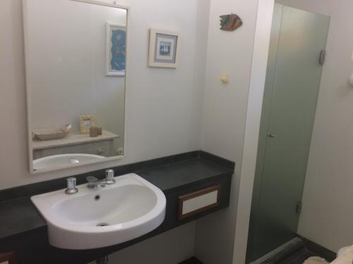 a bathroom with a sink and a mirror at Juquehy - Condomínio de Frente para o Mar in Juquei