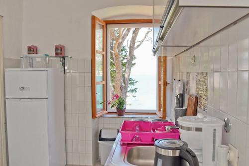 uma cozinha com um lavatório rosa e uma janela em Ribica Apartments em Kotor