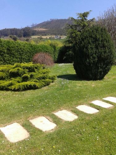 a garden with stepping stones in the grass at Vivienda de Uso Turístico Carballo Blanco 2 in Barral