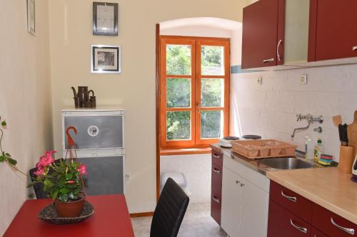a kitchen with a sink and a table and a window at Ribica Apartments in Kotor