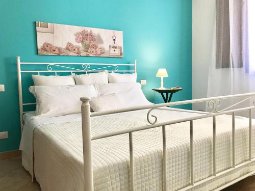 ein Schlafzimmer mit einem weißen Bett mit blauen Wänden in der Unterkunft La Casa più Bella in Custonaci
