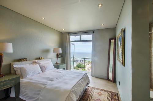 1 dormitorio con cama grande y ventana grande en 10 Elf Beach House, en Groot Brak Rivier