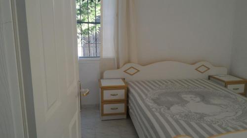 a small bedroom with a bed and a window at Villa Agean Beach in Kuşadası