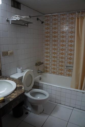 y baño con aseo, bañera y lavamanos. en Hotel El Plaza Centro de Lima, en Lima