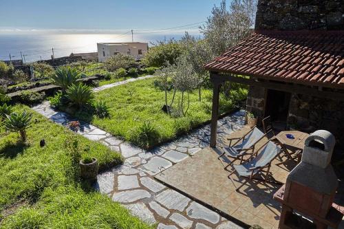 un patio con sillas y un patio con vistas al océano. en Casa Rural Sanjora, en Valverde