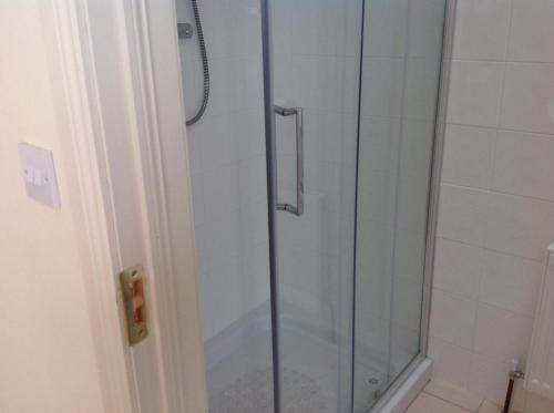 a shower with a glass door in a bathroom at Auntie B's in Ardara