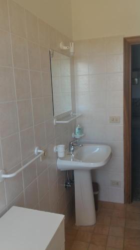 uma casa de banho com um lavatório, um espelho e uma banheira em Borgo Montauto em San Gimignano