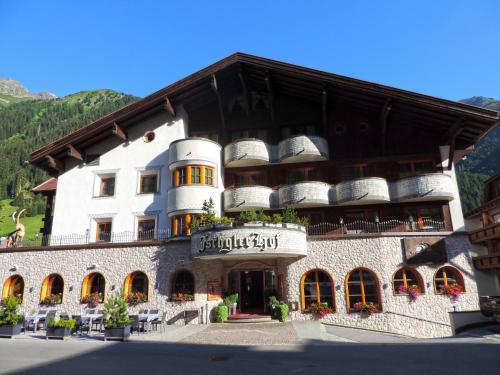 a large white building with baskets on top of it at Alpenhotel Ischglerhof in Ischgl