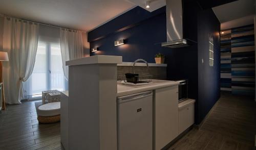 a kitchen with a sink and a blue wall at Aiolis Studios in Porto Koufo