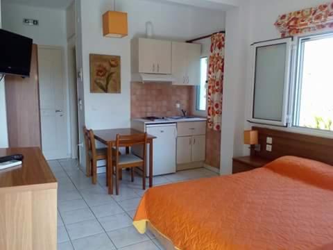 a room with a kitchen and a table and a bed at Potokia Rooms in Kakovatos
