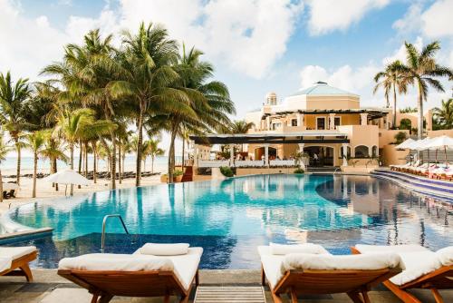 a pool at a resort with palm trees at Royal Hideaway Playacar All-Inclusive Adults Only Resort in Playa del Carmen