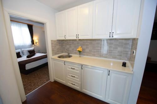 a white kitchen with a sink and a bedroom at Hotel Drim in Struga