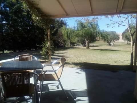 a patio with a table and chairs and a field at Potokia Rooms in Kakóvatos