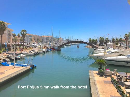 a bridge over a river with boats in a harbor at L'Oasis Hotel in Fréjus