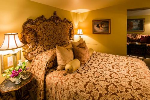a bedroom with a large bed and a table with flowers at Russell Manor Bed & Breakfast in Morrisburg