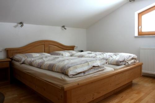 ein Schlafzimmer mit einem Holzbett in einem Zimmer in der Unterkunft Haus Lowe in Filzmoos