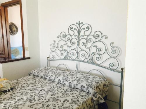 a bedroom with a bed with a metal headboard at La Chiave di Violino in Olbia