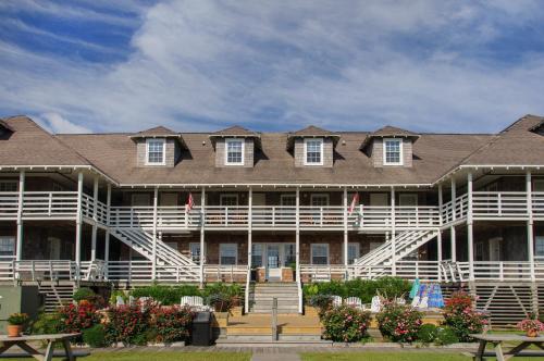 a large building with white railings and a porch at First Colony Inn in Nags Head