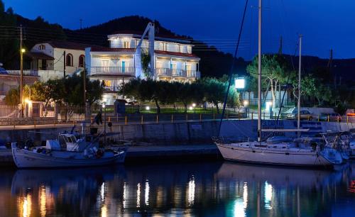 two boats are docked in a marina at night at Aiolis Studios in Porto Koufo
