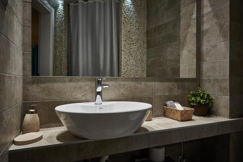 a bathroom with a white sink and a mirror at Aiolis Studios in Porto Koufo