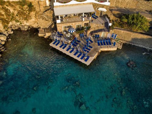 an aerial view of a pool of water with blue chairs at Ischia Blu Resort in Ischia