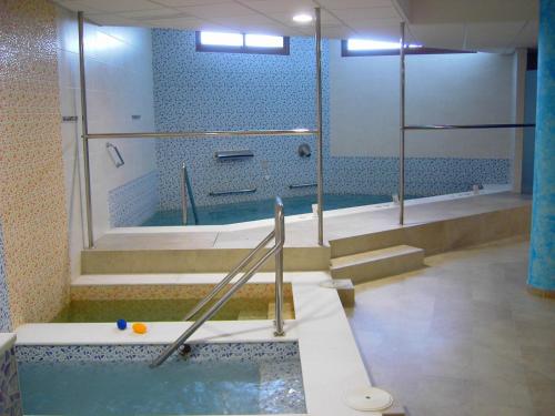 a bathroom with a tub with a shower and a bath tub at Llave de Granada in Alcalá la Real