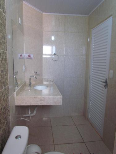 a bathroom with a sink and a toilet at Pousada Quinta Das Aroeiras in Olímpia