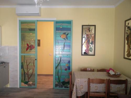 a dining room with a table and a stained glass door at Julia B&B in Crotone