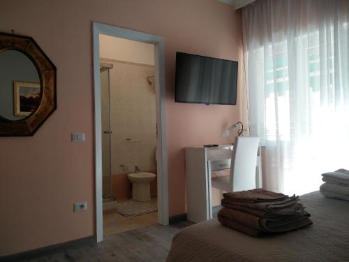 ein Schlafzimmer mit einem Bad mit einem WC und einem Spiegel in der Unterkunft Julia B&B in Crotone