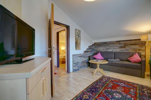a living room with a couch and a flat screen tv at Ferienhof Stöckl in Finkenberg