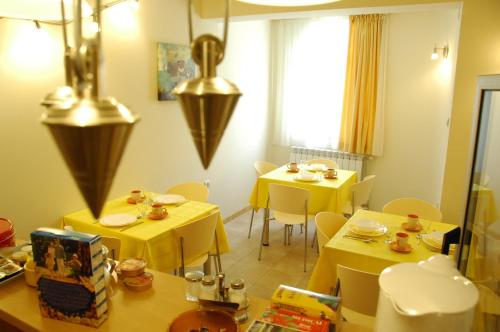 une salle à manger avec des tables jaunes et des chaises jaunes dans l'établissement Villa Nevenka Rooms, à Belgrade