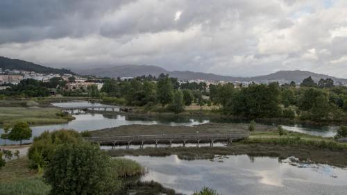 a bridge over a river with a city in the background at Hotel do Parque in Viana do Castelo