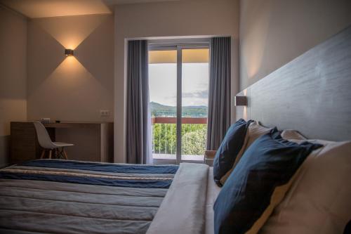 a bedroom with a bed and a large window at Hotel do Parque in Viana do Castelo