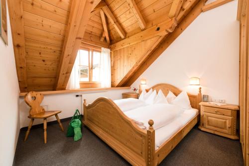 Un dormitorio con una cama grande en una habitación con techos de madera. en Ansitz Wirtsgut - Familienappartements in den Bergen, en Leogang