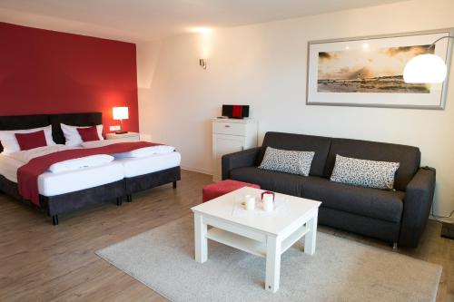 a bedroom with a bed and a couch and a table at Appartements am Binnenhafen in Helgoland