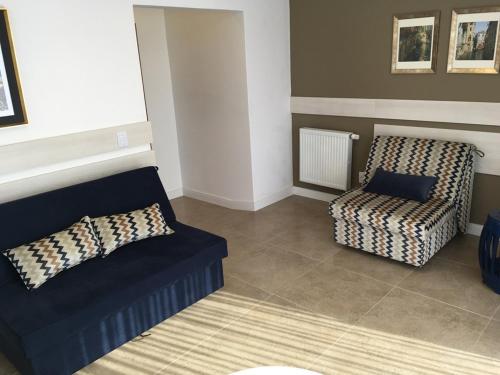a living room with a couch and a chair at Farina Park Hotel in Bento Gonçalves