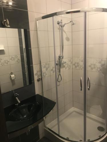 a bathroom with a shower and a sink at Apartamenty Puk Puk in Mrągowo