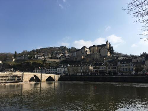 a bridge over a river with a town in the background at Les Maisons du Périgord in Terrasson-Lavilledieu