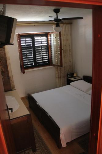 a bedroom with a white bed and a window at App Dujmovic in Supetar