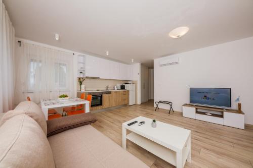 un soggiorno con divano e TV di Apartments MARE a Trogir