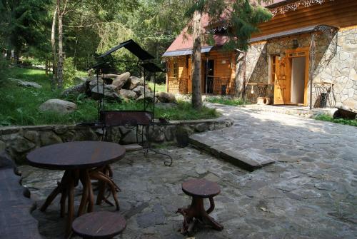 a set of tables and stools in front of a building at Hotel Dykyi Med in Tatariv